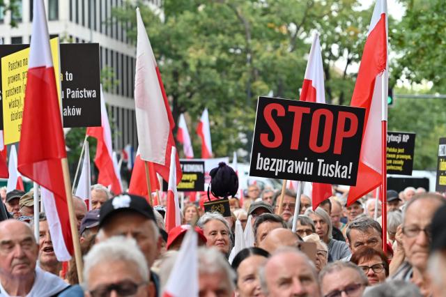 Anti-government protesters shout slogans during a rally outside the Constitutional Court building in Warsaw on September 18, 2026. Over one thousand demonstrators rallied in Warsaw on September 18 to protest the ruling centrist governments moves to investigate the barring of several elected judges from adjudicating in Poland's highest court. (Photo by Mladen ANTONOV / AFP)