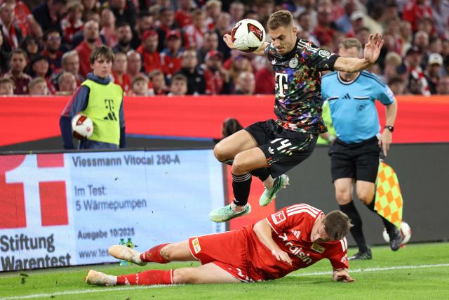 Union Berlin's Swiss midfielder #20 Michael Aebischer (bottom) and Bayern Munich's Croatian defender #44 Josip Stanisic vie for the ball during the German first division Bundesliga football match between FC Bayern Munich and Union Berlin in Munich, southern Germany on September 18, 2026. (Photo by Alexandra BEIER / AFP)