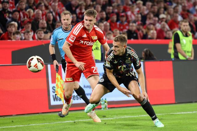 Union Berlin's Swiss midfielder #20 Michael Aebischer (L) and Bayern Munich's Croatian defender #44 Josip Stanisic vie for the ball during the German first division Bundesliga football match between FC Bayern Munich and Union Berlin in Munich, southern Germany on September 18, 2026. (Photo by Alexandra BEIER / AFP)
