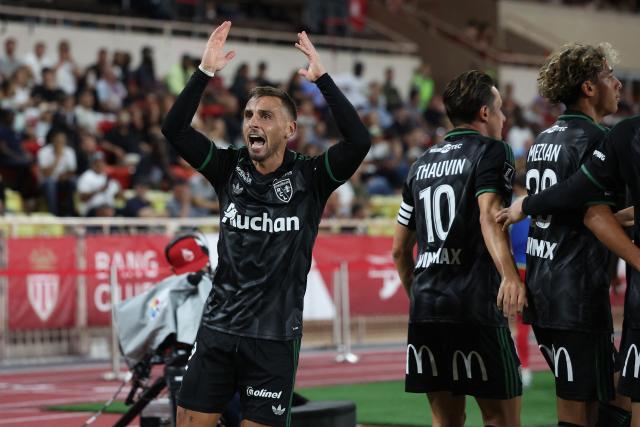 Lens' French defender #02 Ruben Aguilar (L) celebrates his team firts goal during the French L1 football match between AS Monaco and RC Lens at the Stade Louis II in Monaco on September 18, 2026. (Photo by Valery HACHE / AFP)