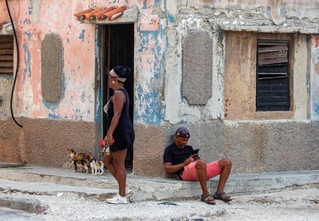 A Cuban uses his mobile phones during a blackout in Havana on September 18, 2026. Cuba was plunged into its seventh massive blackout of the year on September 18, 2026, the energy ministry said, as fuel shortages bite on the US-blockaded island. (Photo by ADALBERTO ROQUE / AFP)