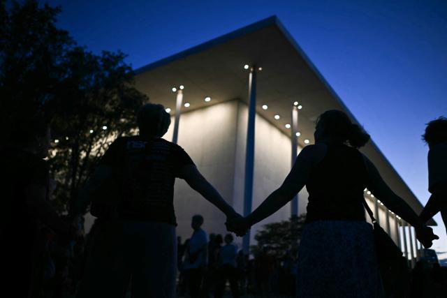 People hold hands during a rally in support of the Kennedy Center in Washington, DC, on September 18, 2026. (Photo by Kent NISHIMURA / AFP)