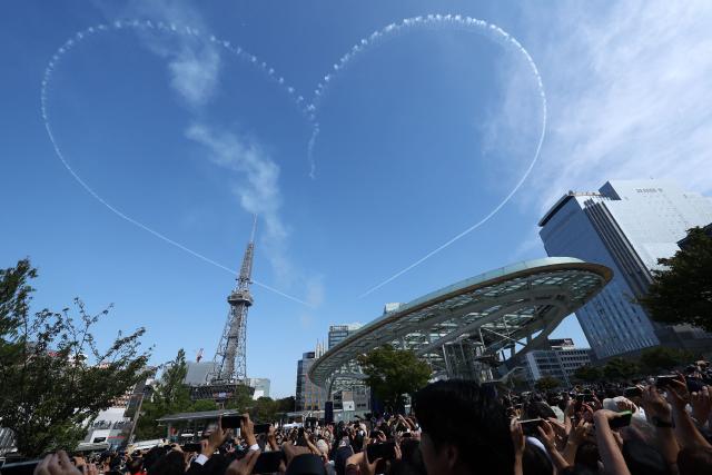 Skywriting in the shape of a heart created by Kawasaki T-4s of the Japan Air Self-Defense Force's Blue Impulse aerobatic demonstration team is seen above Nagoya ahead of the opening ceremony for the 2026 Asian Games on September 19, 2026. (Photo by JIJI Press / AFP) / Japan OUT