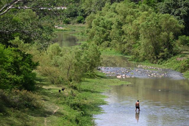 A man stands on the Ostua river in Asuncion Mita, Jutiapa, Guatemala on September 18, 2026. Communities and environmental organizations from Guatemala and El Salvador called on Guatemala's Public Prosecutor's Office to permanently close the operations of Era Dorada mining project four years after a municipal consultation rejected metal mining in the municipality. (Photo by Marvin RECINOS / AFP)