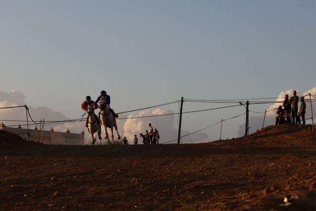 Palestinian jockeys ride during a local horse race in al-Majd, west of the Israeli-occupied West Bank city of Hebron on September 18, 2026. As open land becomes increasingly scarce amid expanding Israeli settlement construction in the occupied West Bank, horse culture has emerged as one of the rare forms of recreation that still draws Palestinians together, from urban neighborhoods to rural villages. (Photo by HAZEM BADER / AFP)