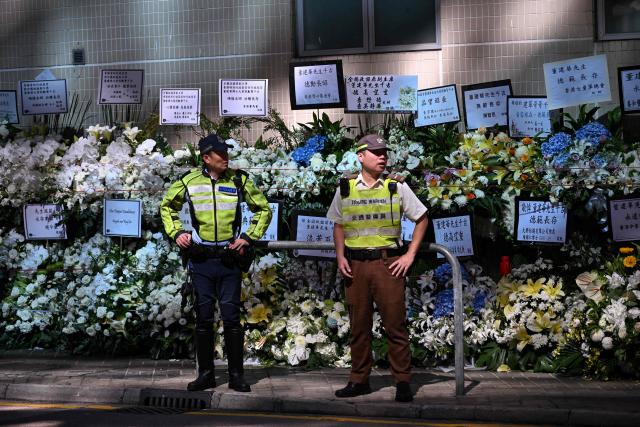 Police and security are seen as mourners arrive to pay respects to Tung Chee-hwa, Hong Kong's first leader after the city's return to Chinese rule, at North Point Funeral Home in Hong Kong on September 19, 2026. Tung, who died on September 8, was a divisive figure, with Chinese state media hailing him as a "renowned patriot" and "close friend of the Communist Party", though some of his policies sparked widespread protests. (Photo by Peter PARKS / AFP)