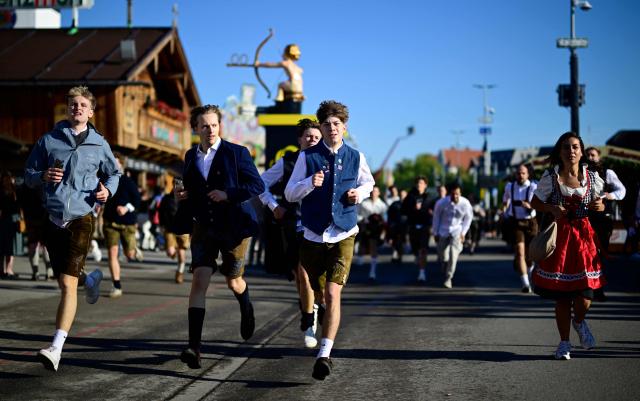 Visitors run to get a place in one of the beer tents prior to the official opening of the 191st Oktoberfest beer festival in Munich, southern Germany on September 19, 2026. The world's biggest beer festival Oktoberfest runs until October 4, 2026. (Photo by Tobias SCHWARZ / AFP)