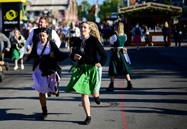 Visitors run to get a place in one of the beer tents prior to the official opening of the 191st Oktoberfest beer festival in Munich, southern Germany on September 19, 2026. The world's biggest beer festival Oktoberfest runs until October 4, 2026. (Photo by Tobias SCHWARZ / AFP)