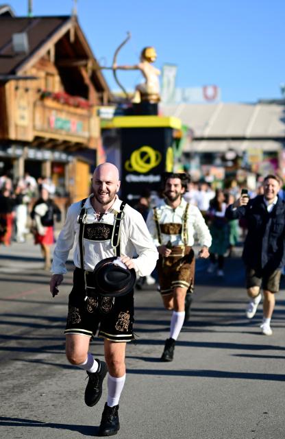 Visitors run to get a place in one of the beer tents prior to the official opening of the 191st Oktoberfest beer festival in Munich, southern Germany on September 19, 2026. The world's biggest beer festival Oktoberfest runs until October 4, 2026. (Photo by Tobias SCHWARZ / AFP)