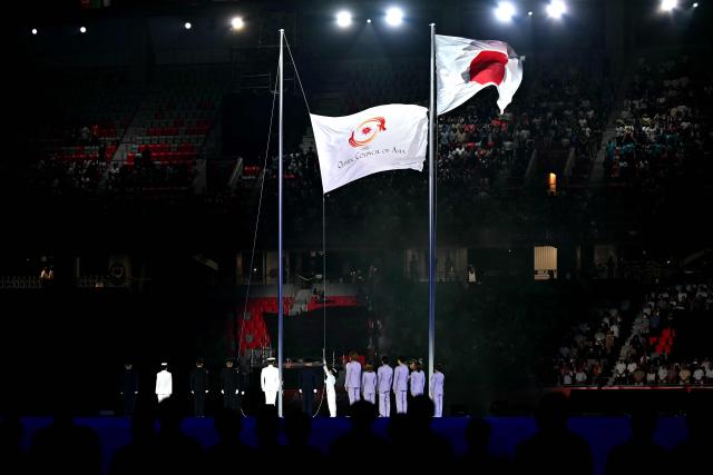 The Olympic Council of Asia's flag (L) is being hoisted during the opening ceremony of the 2026 Asian Games at Paloma Mizuho Stadium in Nagoya on September 19, 2026. (Photo by MOHD RASFAN / AFP)