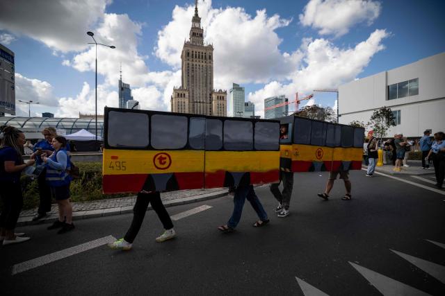 A group of fans dressed as a cardboard mock-up Warsaw tram is entertaining spectators during the 12th European Tram Driver Championship in front of the Palace of Culture and Science on Marszalkowska Street in central Warsaw on 19 September 2026. 26 teams – each consisting of a female and a male tram driver, from 25 cities and 24 European countries, plus one guest team from Melbourne, Australia – show off their driving skills in a series of challenging competitions that test their precision, concentration, feel for the vehicle, and control of the tram. (Photo by Wojtek RADWANSKI / AFP)