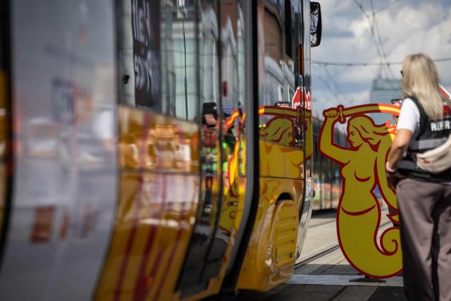 A tram is passing by a cardboard figure of the Warsaw Mermaid – the symbol of the town – during an competition focused on precisely avoiding obstacles during the 12th European Tram Driver Championship in front of Palace of Culture and Science on Marszalkowska street in Warsaw's downtown, on September 19, 2026. 26 teams – each consisting of a female and a male tram driver, from 25 cities and 24 European countries, plus one guest team from Melbourne, Australia – show off their driving skills in a series of challenging competitions that test their precision, concentration, feel for the vehicle, and control of the tram. (Photo by Wojtek RADWANSKI / AFP)