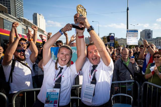 Members of Czech Republic's team from Prague, Vendula Tmejova (L) and Zdenek Rychtar (R), celebrate after winning the 12th European Tram Driver Championship in front of the Palace of Culture and Science on Marszalkowska Street in downtown Warsaw, on September 19, 2026. 26 teams – each consisting of a female and a male tram driver, from 25 cities and 24 European countries, plus one guest team from Melbourne, Australia – show off their driving skills in a series of challenging competitions that test their precision, concentration, feel for the vehicle, and control of the tram. (Photo by Wojtek RADWANSKI / AFP)