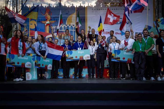 Winners and other participants celebrate after the 12th European Tram Driver Championship in front of the Palace of Culture and Science on Marszalkowska Street in downtown Warsaw, on September 19, 2026. 26 teams – each consisting of a female and a male tram driver, from 25 cities and 24 European countries, plus one guest team from Melbourne, Australia – show off their driving skills in a series of challenging competitions that test their precision, concentration, feel for the vehicle, and control of the tram. (Photo by Wojtek RADWANSKI / AFP)