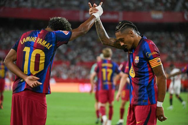 Barcelona's Brazilian forward #11 Raphinha (R) celebrates with teammate Spanish forward #10 Lamine Yamal after scoring his team's second goal during the Spanish league football match between Sevilla FC and FC Barcelona at the Ramon Sanchez Pizjuan stadium in Seville on September 19, 2026. (Photo by JORGE GUERRERO / AFP)