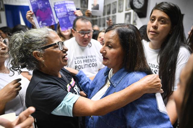 Soraya Gonzalez, a relative of a political prisoner, embraces the head of Venezuela's opposition delegation, Dinorah Figuera (C), during a meeting with relatives of political prisoners in Caracas on September 19, 2026. (Photo by Juan BARRETO / AFP)