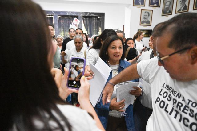The head of Venezuela's opposition delegation, Dinorah Figuera (C), and other delegation members meet with relatives of political prisoners in Caracas on September 19, 2026. (Photo by Juan BARRETO / AFP)