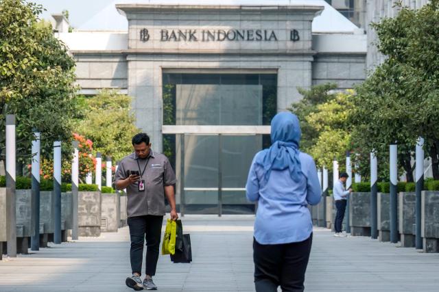 Pedestrians walk towards the Bank Indonesia headquarters in Jakarta on September 21, 2026. (Photo by BAY ISMOYO / AFP)