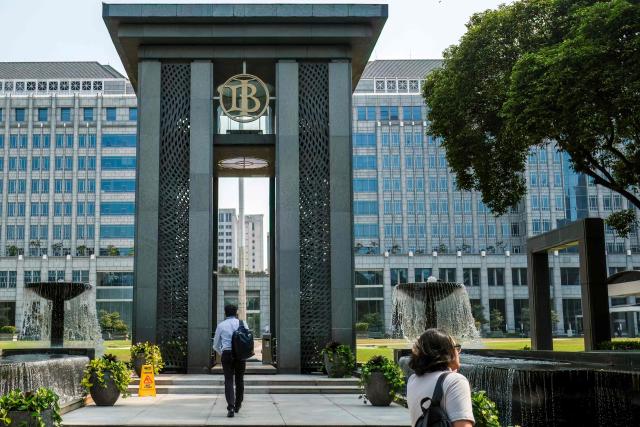 Pedestrians walk towards the Bank Indonesia headquarters in Jakarta on September 21, 2026. (Photo by BAY ISMOYO / AFP)