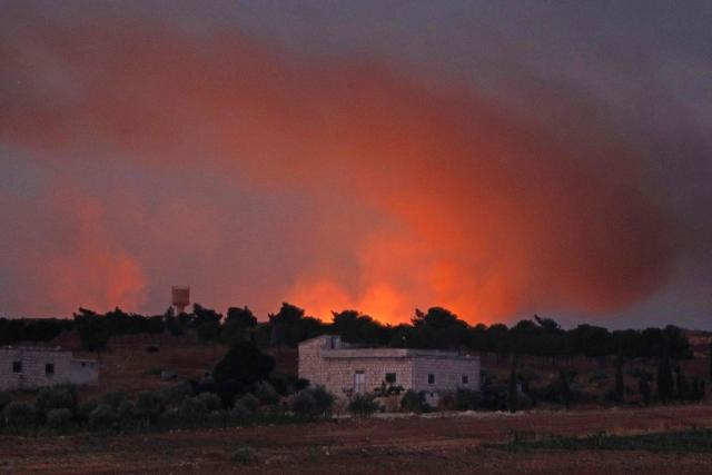 Fire and smoke rise following a series of explosions at a Syrian army site in the vicinity of Al-Eis town early on September 21, 2026. At least four people were injured following a series of explosions at an Aleppo army site in northern Syria, state media reported. The cause of the explosions was not immediately known. (Photo by Abdulaziz KETAZ / AFP)