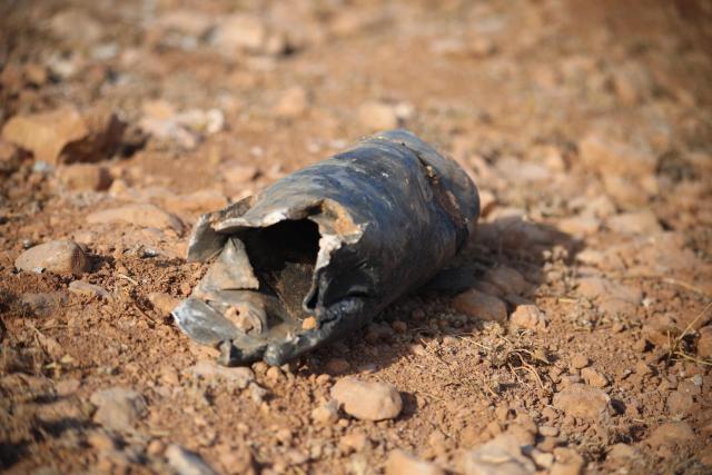 A munition debris lies on the ground following a series of explosions at a Syrian army site in the vicinity of Al-Eis town on September 21, 2026. At least four people were injured following a series of explosions at an Aleppo army site in northern Syria, state media reported. The cause of the explosions was not immediately known. (Photo by Abdulaziz KETAZ / AFP)
