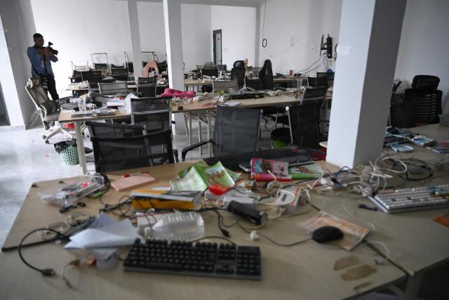 A journalist takes pictures of abandoned equipment at a closed cyber scam centre in Bavet town, Svay Reang province on September 21, 2026. Cambodia this week hosts officials from more than 20 countries for a conference on combating online scammers, seeking to showcase its own crackdown under increasing international pressure. (Photo by TANG CHHIN SOTHY / AFP)