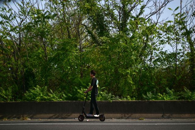 A man rides an electric scooter on the Lyon urban ring road in Lyon, central France on September 21, 2026. (Photo by Olivier CHASSIGNOLE / AFP)