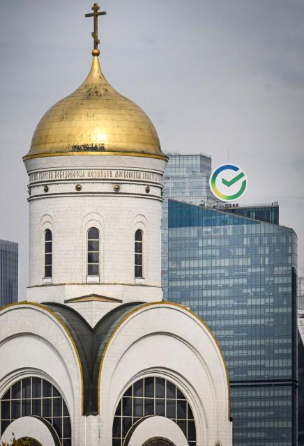 The logo of Russia's state-owned Sber bank is seen atop its head office behind an Orthodox church in western Moscow on September 21, 2026. (Photo by Alexander NEMENOV / AFP)