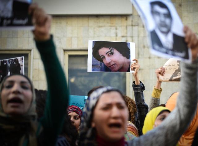 (FILES) Egyptian protesters hold a portrait of Shaimaa al-Sabbagh (C) during a demonstration in Cairo on January 29, 2015. Egypt has paid compensation to the family of activist and poet Shaimaa al-Sabbagh, over a decade after she was shot dead by police while laying a wreath in memory of slain protesters, her family's lawyer said on September 21, 2026. (Photo by Mohamed el-Shahed / AFP)