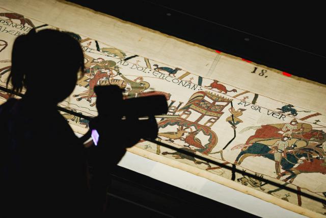(FILES) A camera operator videos a section of the Bayeux Tapestry during the press preview at the British Museum in London on September 7, 2026. The British Museum has banned visitors from taking pictures of the Bayeux Tapestry in order to keep the crowds flowing through an unprecedented London exhibition, a spokesperson confirmed on September 21, 2026. (Photo by Adrian DENNIS / AFP)