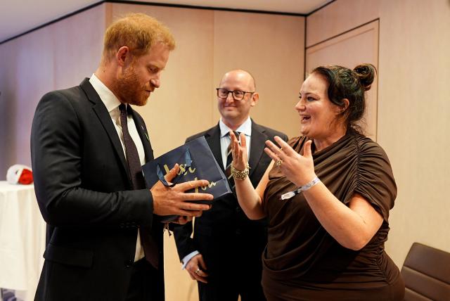 Britain's Prince Harry, Duke of Sussex (L) receives a gift of a mug and tea towel for his new house by the winner of the Inspirational Nurse, Rachel Shanahan (R) and her husband Paul (C), during the annual WellChild Awards at the Royal Lancaster Hotel in London on September 21, 2026. WellChild is the national charity for seriously ill children and their families. The WellChild Awards celebrate the inspiring qualities of some of the country's seriously ill young people and the dedication of those who care for and support them. (Photo by Aaron Chown / POOL / AFP)