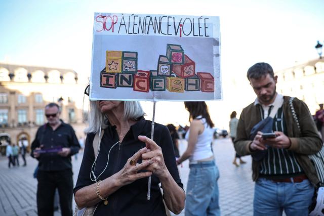 A protester holds a placard with an orthography modification to create a double meaning to read "Stop to stolen/raped childhood; Incest" during a demonstration calling for the protection of children and a comprehensive law against sexual violence, organised by the Feminist and Child Rights Coalition for a Comprehensive Framework Law Against Sexual Violence at Place Vendome in Paris on September 21, 2026. Some 130 gatherings were announced across France as lawmakers began debates on a "comprehensive" bill against gender-based and sexual violence. (Photo by SIMON WOHLFAHRT / AFP)