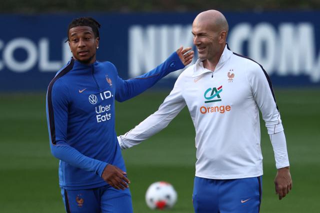 France's head coach Zinedine Zidane (R) greets France's forward Michael Olise (L) at the end of a training session four days ahead of France's UEFA Nations League football match against Turkey in Clairefontaine-en-Yvelines outside Paris, on September 21, 2026. The gathering is the first of the French national team under its new coach Zinedine Zidane, appointed on July 28, 2026 on a four-year contract. The Nations League, which France won in 2021, will dominate Zidane's attention in the coming months before the draw for the Euro 2028 qualifying tournament takes place in early December. (Photo by FRANCK FIFE / AFP)