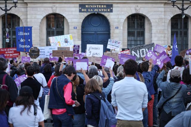 A protester holds a placard reading "I was 9 years old" along with others during a demonstration calling for the protection of children and a comprehensive law against sexual violence, organised by the Feminist and Child Rights Coalition for a Comprehensive Framework Law Against Sexual Violence outside the Justice Ministry on Place Vendome in Paris on September 21, 2026. Some 130 gatherings were announced across France as lawmakers began debates on a "comprehensive" bill against gender-based and sexual violence. (Photo by SIMON WOHLFAHRT / AFP)