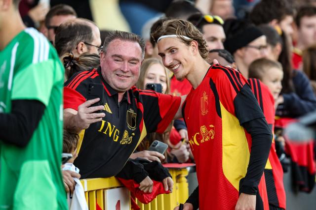 Belgium's forward Mika Godts (R) poses for a selfie with a fan during a training session ahead of the team's UEFA Nations League football match against Italy at the national training center in Tubize, on September 21, 2026. (Photo by BRUNO FAHY / Belga / AFP) / Belgium OUT