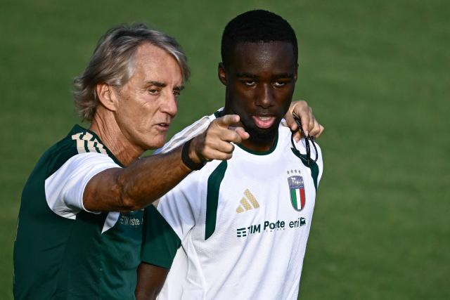 Italy's head coach Roberto Mancini talks to Italy's defender Michael Kayode during a training session in Coverciano, near Florence, on September 21, 2026, ahead of Italy's UEFA Nations League football match against Belgium. (Photo by Filippo MONTEFORTE / AFP)