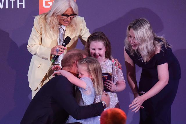 Britain's Prince Harry, Duke of Sussex gets a hug from Margot Jones-Billington’s sister Adeleigh on stage during the annual WellChild Awards at the Royal Lancaster Hotel in London on September 21, 2026. WellChild is the national charity for seriously ill children and their families. The WellChild Awards celebrate the inspiring qualities of some of the country's seriously ill young people and the dedication of those who care for and support them. (Photo by Aaron Chown / POOL / AFP)
