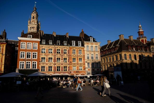 Pedstrians walk past the "Beffroi de la Chambre de Commerce" near the Grand'Place in Lille, northern France, on September 21, 2026. (Photo by Sameer Al-DOUMY / AFP)