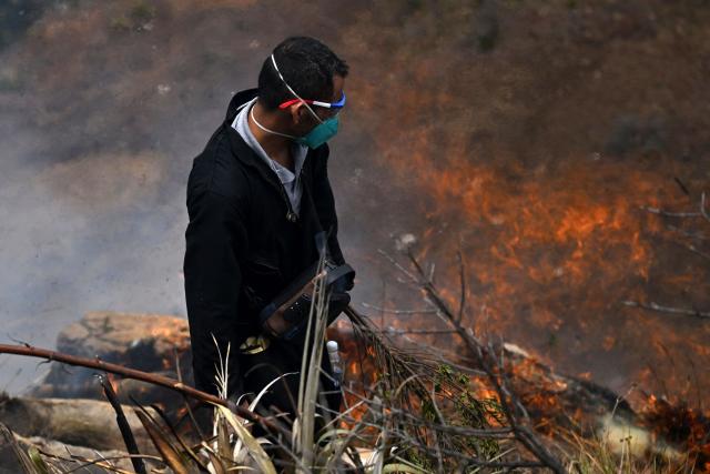 A volunteer works to extinguish a wildfire on Ritoque Hill in the municipality of Villa de Leyva, Boyaca department, Colombia, on September 21, 2026. (Photo by Raul ARBOLEDA / AFP)