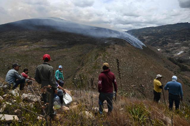 Volunteers stand in an area affected by a wildfire on Ritoque Hill in the municipality of Villa de Leyva, Boyaca department, Colombia, on September 21, 2026. (Photo by Raul ARBOLEDA / AFP)