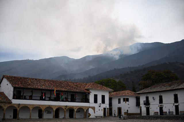 Smoke rises from a wildfire on Ritoque Hill overlooking the main square of Villa de Leyva in Boyaca department, Colombia, on September 21, 2026. (Photo by Raul ARBOLEDA / AFP)