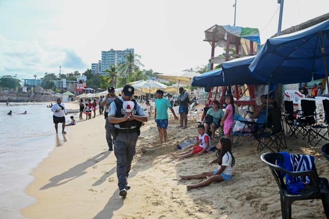 A member of the Mexican National Guard makes an announcement to residents and visitors about the approach of Hurricane Polo along a beach in Acapulco, Guerrero state, Mexico, on September 21, 2026. Hurricane Polo formed off Mexico's Pacific coast on September 21 and is expected to strengthen in the coming days, though it is not forecast to make landfall, the U.S. National Hurricane Centre (NHC) announced. (Photo by Francisco Robles / AFP)