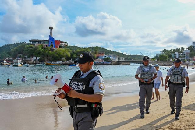 A member of the Mexican National Guard makes an announcement to residents and visitors about the approach of Hurricane Polo along a beach in Acapulco, Guerrero state, Mexico, on September 21, 2026. Hurricane Polo formed off Mexico's Pacific coast on September 21 and is expected to strengthen in the coming days, though it is not forecast to make landfall, the U.S. National Hurricane Centre (NHC) announced. (Photo by Francisco Robles / AFP)