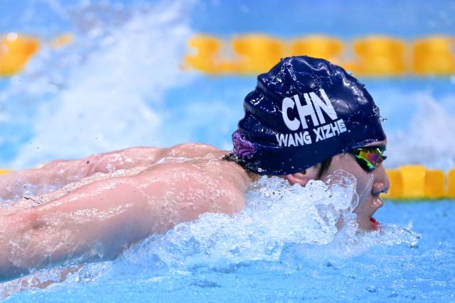 China's Wang Xizhe competes in a heat of the men's 4 x 100m medley relay swimming event during the 2026 Asian Games at the Tokyo Aquatics Centre in Tokyo on September 22, 2026. (Photo by Yuichi YAMAZAKI / AFP)