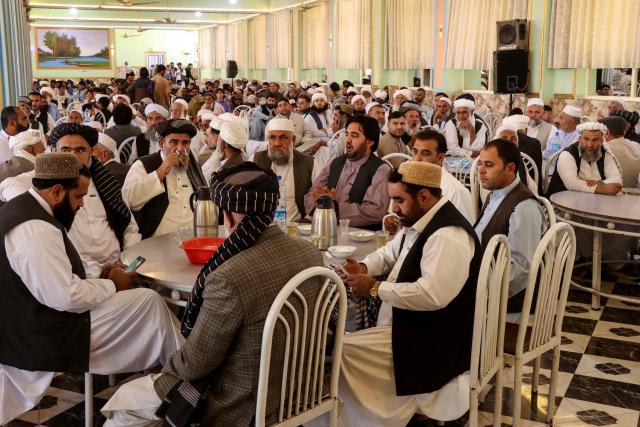 Family members of Afghan grooms gather during a mass marriage ceremony at a wedding hall in Afghanistan's Farah province on September 21, 2026. (Photo by Mohsen KARIMI / AFP)