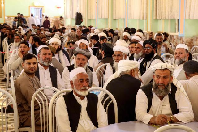 Family members of Afghan grooms gather during a mass marriage ceremony at a wedding hall in Afghanistan's Farah province on September 21, 2026. (Photo by Mohsen KARIMI / AFP)