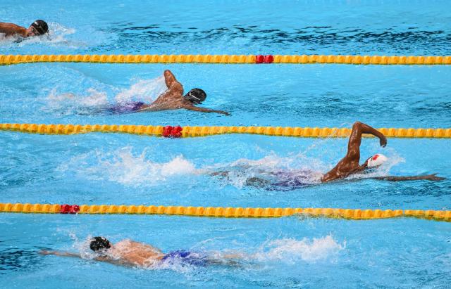 China's Zhang Zhanshuo (R) competes in the final A of the men's 1500m freestyle swimming event during the 2026 Asian Games at the Tokyo Aquatics Centre in Tokyo on September 22, 2026. (Photo by ANDREW CABALLERO-REYNOLDS / AFP)