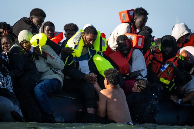 Migrants try to reach a smugglers' boat attempting to cross the English Channel off the beach of Merville-Franceville-Plage, northwestern France, on September 21, 2026. As crossings of the English Channel become increasingly difficult from northern French beaches, migrants are trying new routes to reach England from southern regions such as the Calvados department, where the Channel is wider than along the northern French coast. (Photo by Guillaume SALIGOT / AFP)