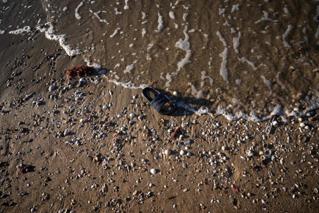 A flip-flop is seen on the beach after migrants boarded a smuggler's boat in an attempt to cross the English Channel off the beach of Merville-Franceville-Plage, northwestern France, on September 21, 2026. As crossings of the English Channel become increasingly difficult from northern French beaches, migrants are trying new routes to reach England from southern regions such as the Calvados department, where the Channel is wider than along the northern French coast. (Photo by Guillaume SALIGOT / AFP)
