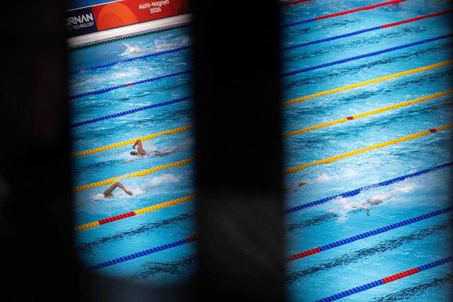 China's Zhang Zhanshuo (L) competes in the final A of the men's 1500m freestyle swimming event during the 2026 Asian Games at the Tokyo Aquatics Centre in Tokyo on September 22, 2026. (Photo by ANDREW CABALLERO-REYNOLDS / AFP)